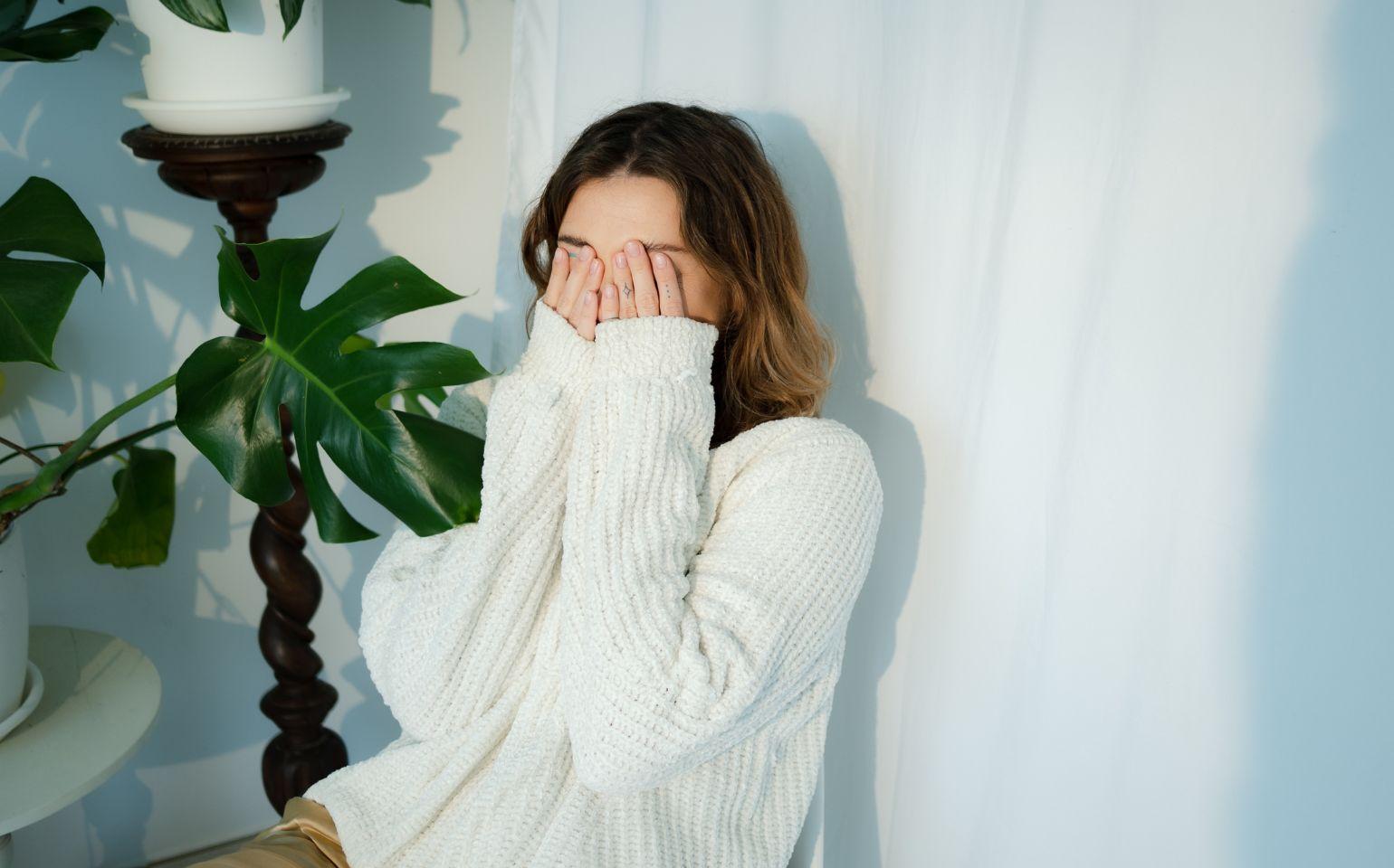 恥ずかしさで顔を隠す女性